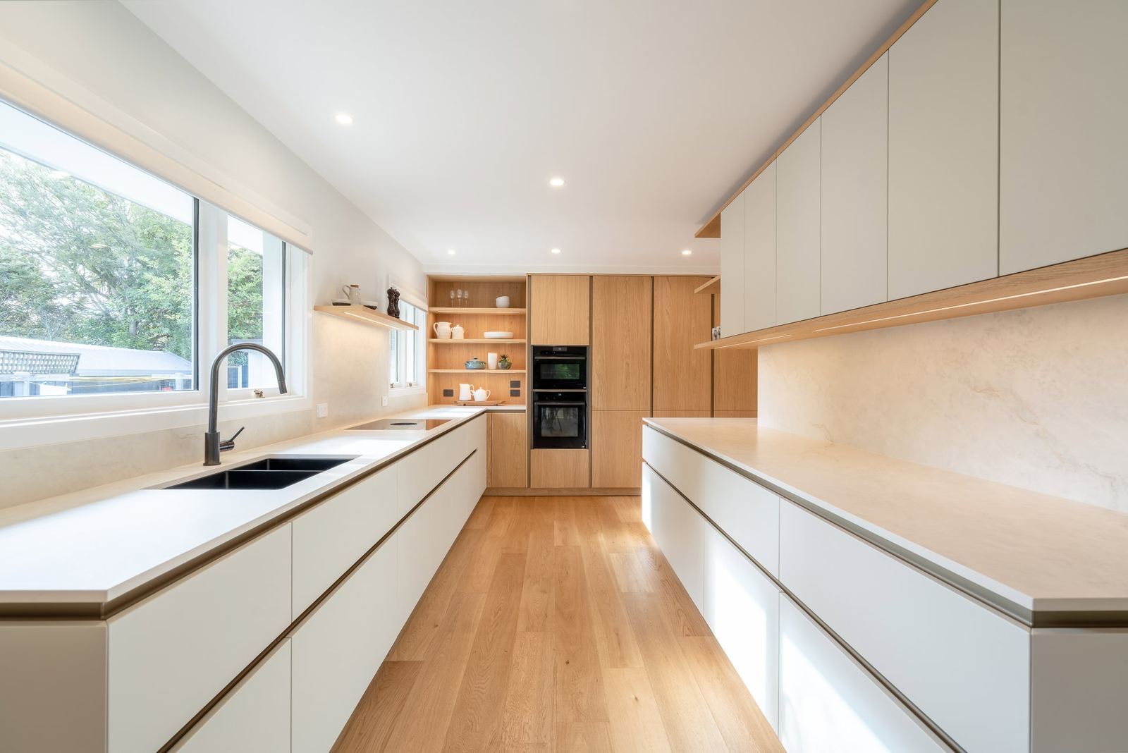 Küche in Grauweiß mit Hochschränken in Eichenfurnier